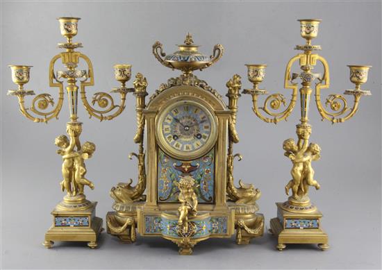 A third quarter of the 19th century French champlevé enamel and ormolu clock garniture, height clock 14in. candelabra 14.75in.